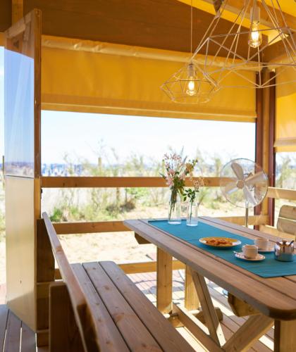 Entspannungsbereich am Strand mit Holztisch und Meerblick.