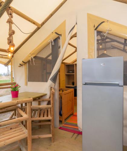 Glamping-Zeltinnenraum mit Tisch und Kühlschrank.