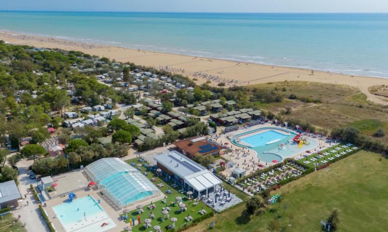 Aerial view of a campsite with pools near the beach.