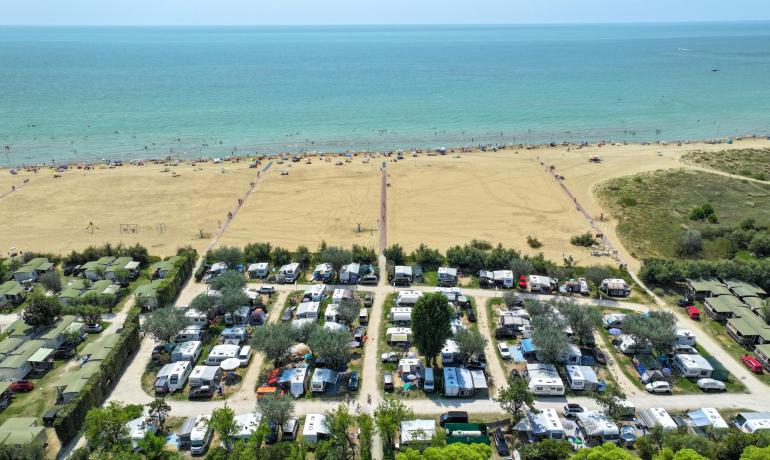 Campingplatz nahe dem Strand mit Wohnwagen und Zelten.