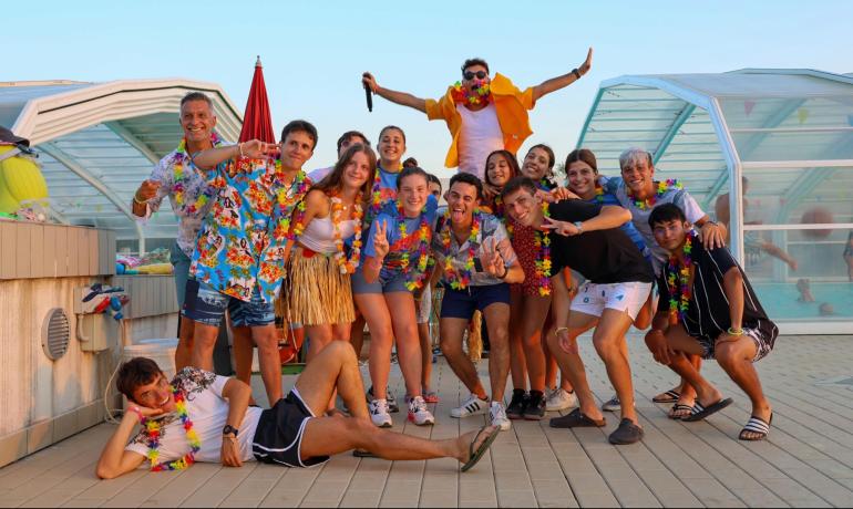 Group of friends celebrating in colorful Hawaiian outfits.