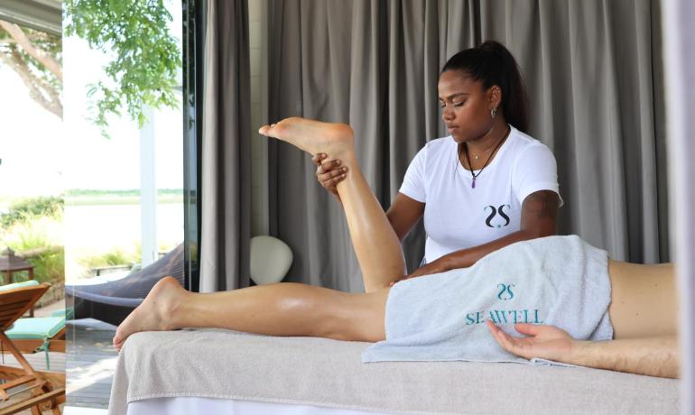 Therapeutic massage in a relaxing setting with an outdoor view.