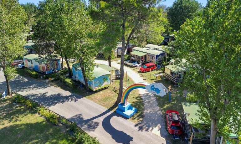 Holiday village with colorful mobile homes and rainbow entrance.