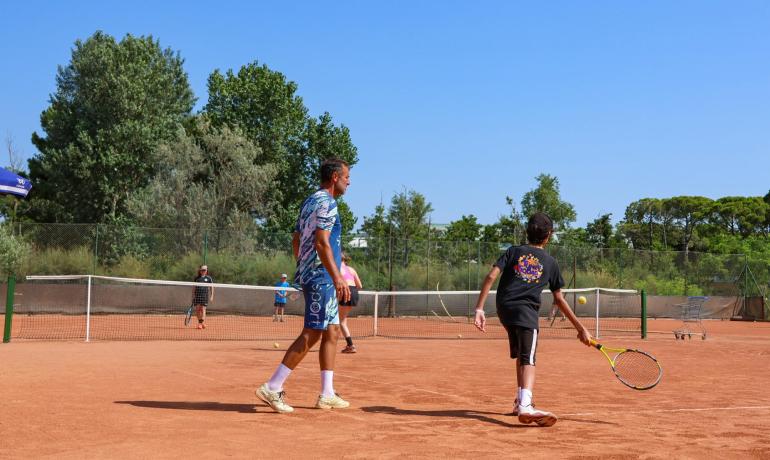 Tennis match on clay court, sunny day.