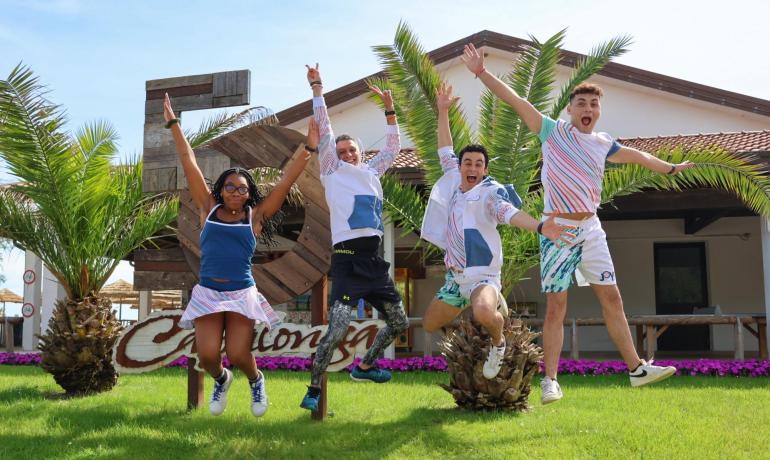 Group of friends jumping happily in front of a tropical beach.